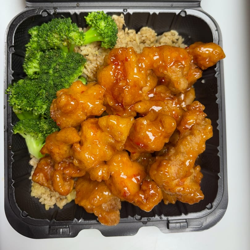 Thai Corner Bistro's orange chicken with broccoli and rice in a black takeout container.