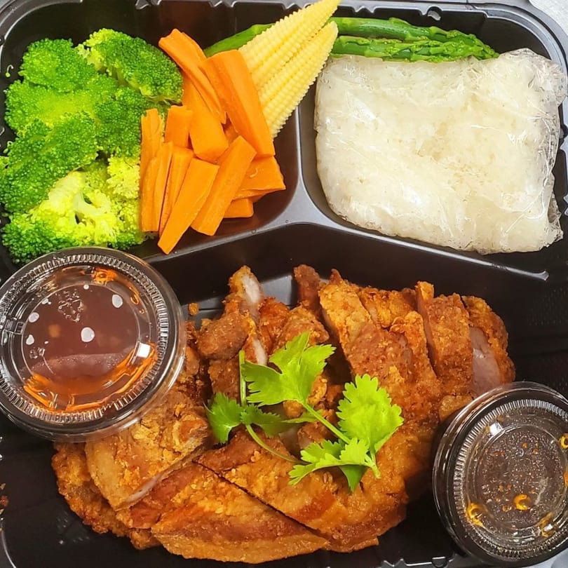 Thai Corner Bistro's fried chicken with sticky rice, broccoli, carrots, baby corn, and sauces in a bento box.
